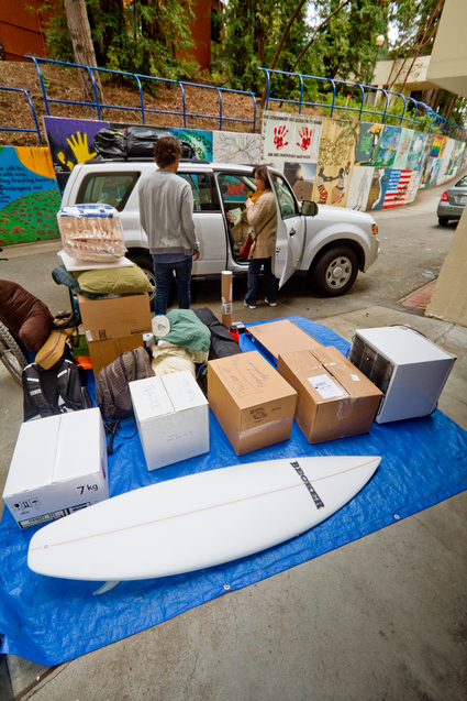 Photo of student moving in with boxes, surfboard