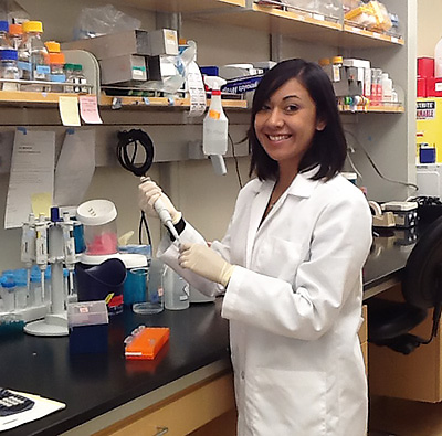 Laura Jimenez in lab coat with pipette