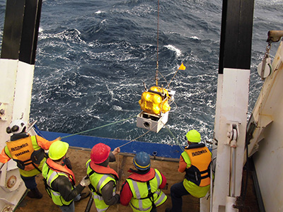 instruments being lowered into the ocean from a ship