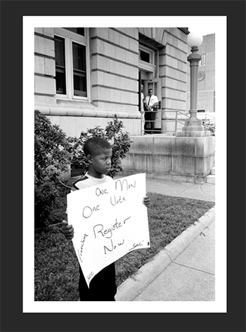 Samual Newhall, 8, demonstrating all alone in front of the Dallas County Courthouse in Sel