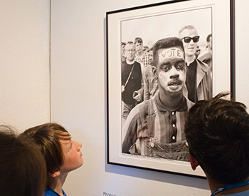 Students look at historical photographs from renowned photojournalist Matt Herron, documen