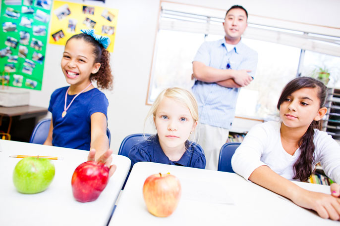 Photo of smiling elementary school children with apples