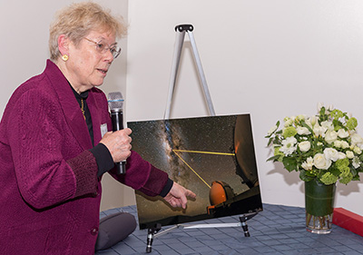 Sandra Faber pointing to framed photograph
