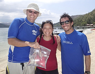 researchers on beach with specimens in bag