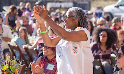A woman applauds at the UC Santa Cruz Farm and Garden 50th anniversary celebration.
