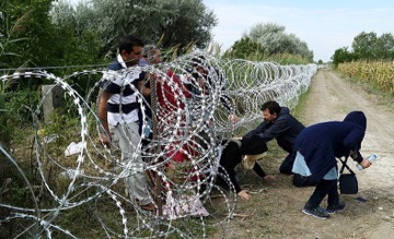 Photo of migrants crawling under barbed wire in Hungary