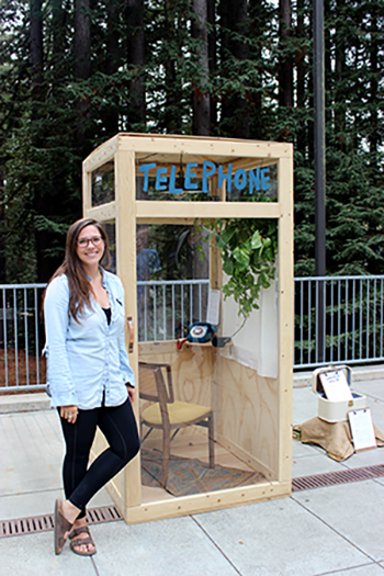 UC Santa Cruz alumna Morgan Brown with her phone booth in the Humanities Courtyard 