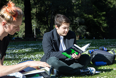 students reading in a field