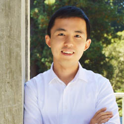 Assistant Professor Kai Zhu poses outside a building on the UCSC campus