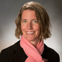 Regina Langhout posing indoors wearing a pink scarf