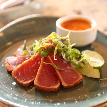 Seared tuna on a plate with dipping sauce