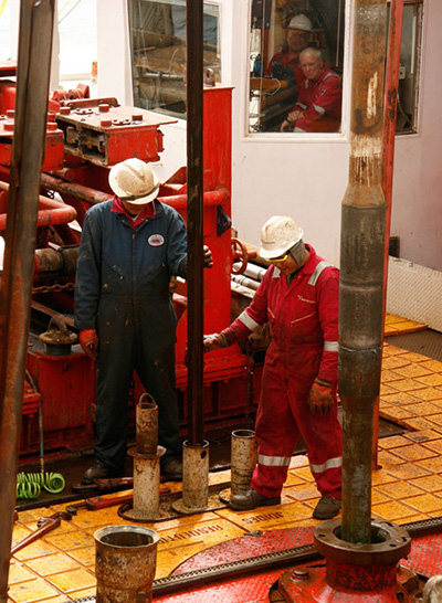 two workers with drilling rig