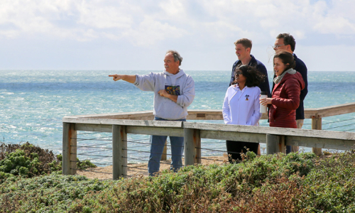 Professor and students looking at the coastline