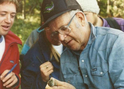 Ken Norris holding a lizard as students watch