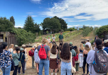 Students gather in an agricultural field around instructors