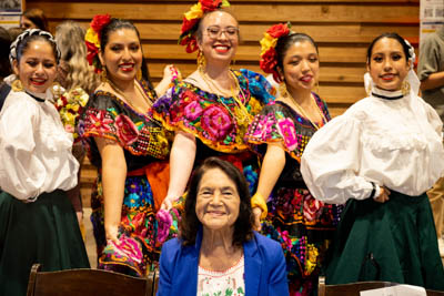 Dolores Huerta, with students in traditional Mexican folkloric dance dresses