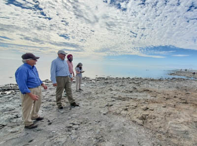 A group of people stand at the water's edge