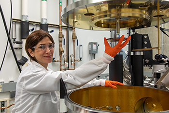 Shiva Abbaszadeh using large metal equipment in her lab.