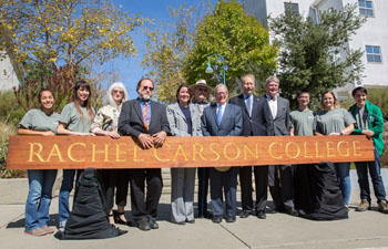people standing with rachel carson college sign