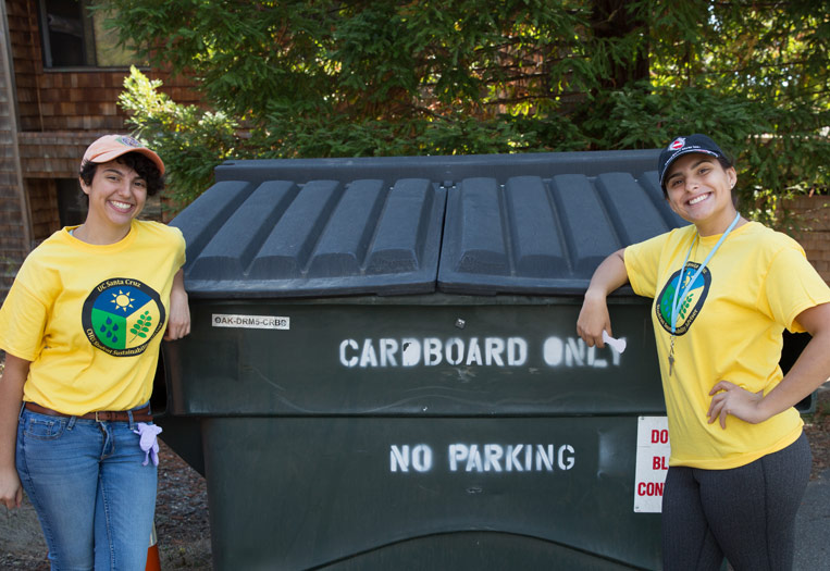 Students post infront recycling trash container