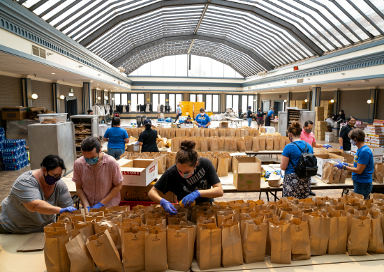 Workers pack meals in bags for families affected by wildland fires.