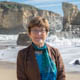 Anne Kapuscinski standing along the coast in front of breaking waves.