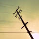 Overhead powerlines in the fog, silhouetted against the sun and sky