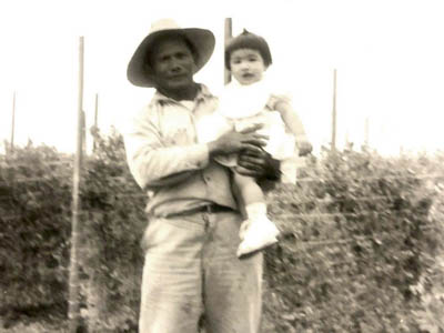 Leon Deocampo holding his baby niece in front of a sugar pea field circa 1959.