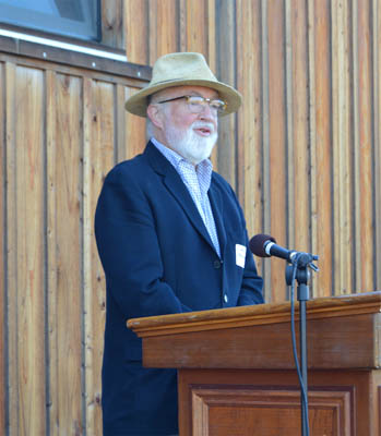 Reinarman at a podium in front of the barn. 