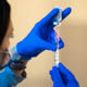 A health care worker filling a syringe with vaccine
