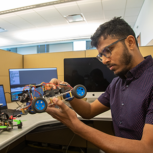 Adeel Akhtar works on a robotic system in the Hybrid Systems Lab. 