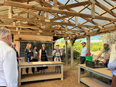 People talk together at an outdoor farm structure