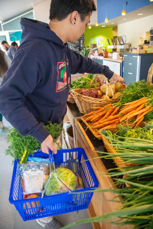 A student holding a shopping basic with produce and other food in the UCSC free market