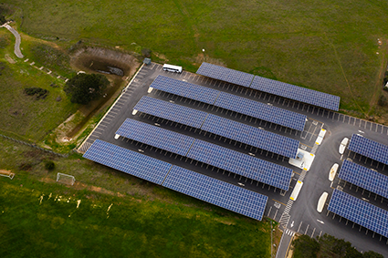 Aerial view of five rows of solar panels in a parking lot on the UCSC campus.