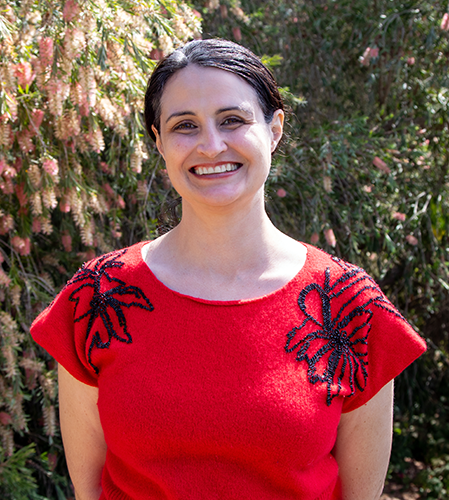 Portrait of Samantha Gorman wearing a red shirt with black details.