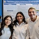 Smiling students in front of research poster