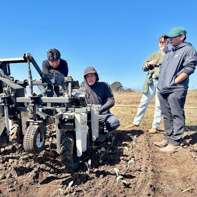 students in a field with an agriculture robot