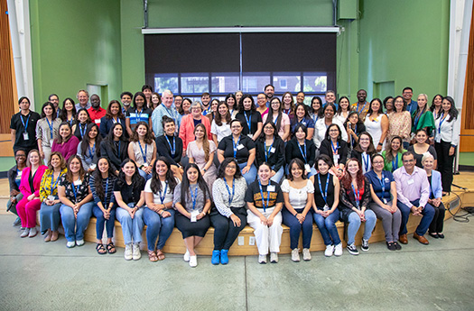 Around 75 conference attendees post for a group photo.