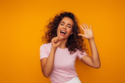 A woman singing into an imaginary microphone