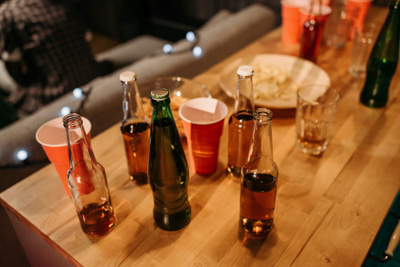 empty beer bottles and cups on a table