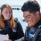 Smiling students in SCUBA wetsuits