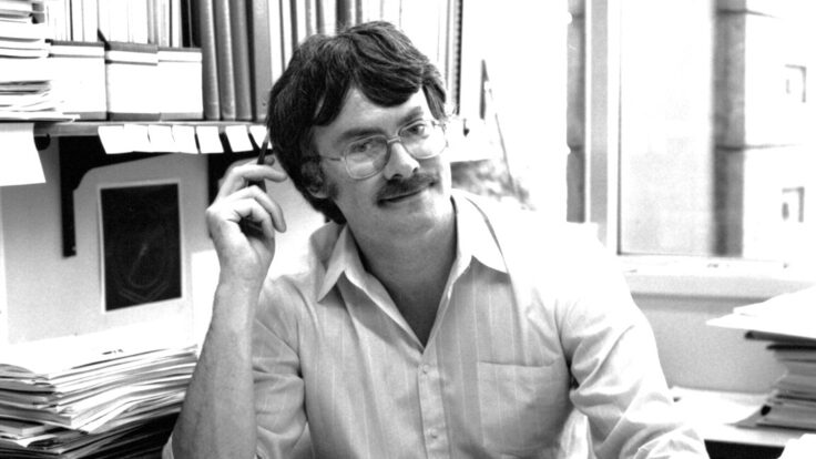 Black and white historical photo of physicist Michael Riordan in office