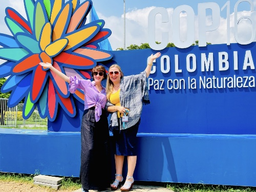 Picture of Rosalind Helfland, on left, and Jenna Shinen, on right, in front of a sign