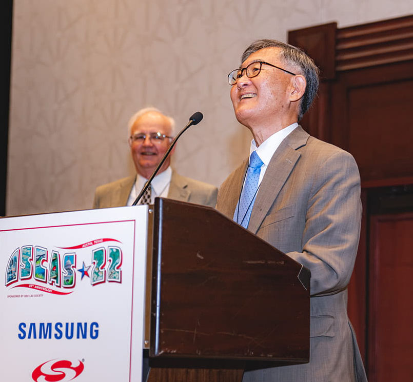 Steve Kang smiles while standing at a podium