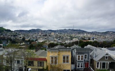 Aerial view of Houses, Cars. Cityscape, streets, and mountians of San Francisco in Potrero Hill Neighborhood with power-lines and cars parked on street.