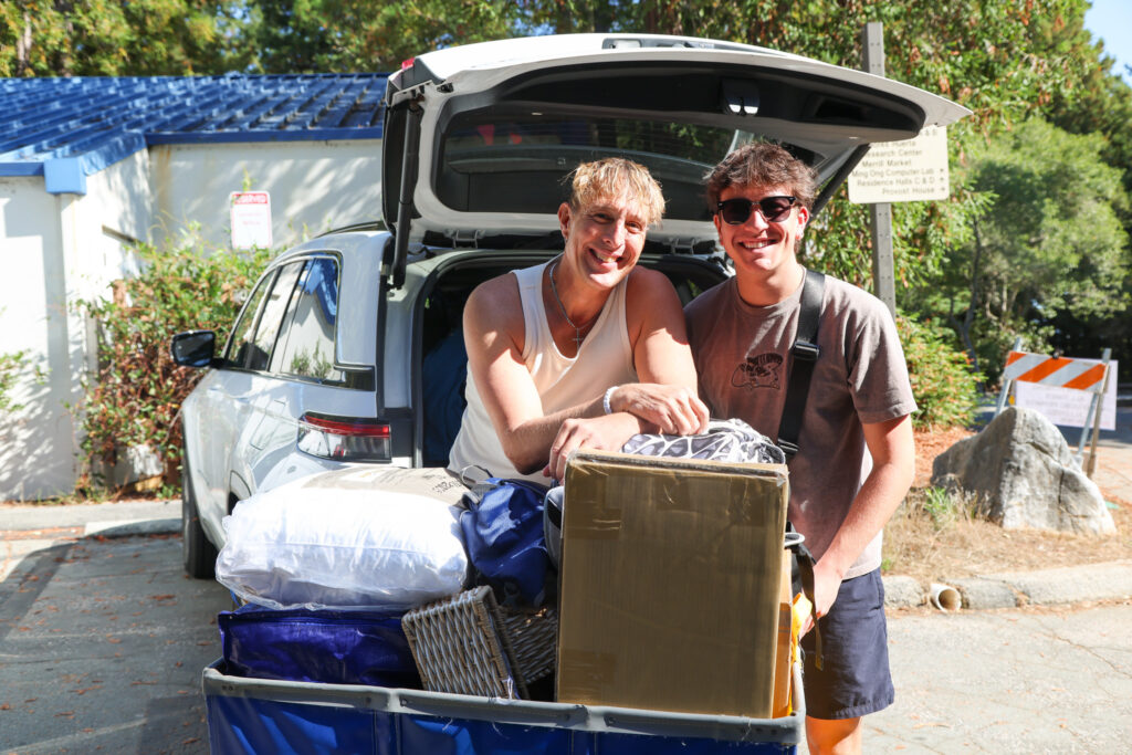 Father and son unload boxes from back of truck