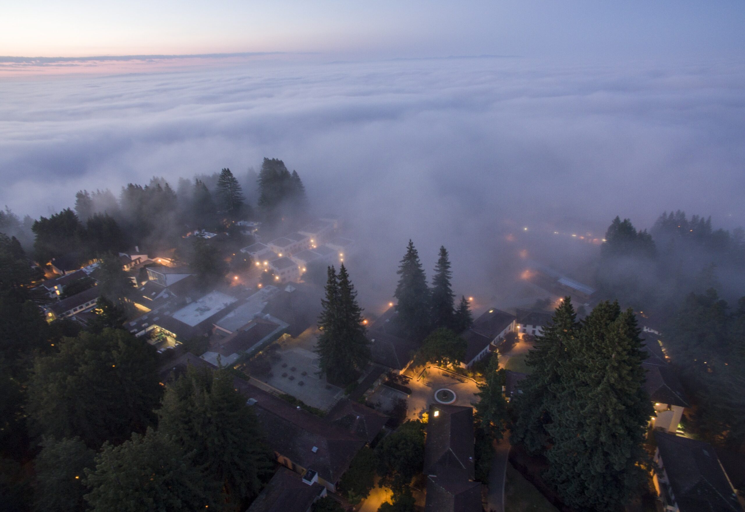 Aerial photo of coastal fog shrouding campus buildings in the evening