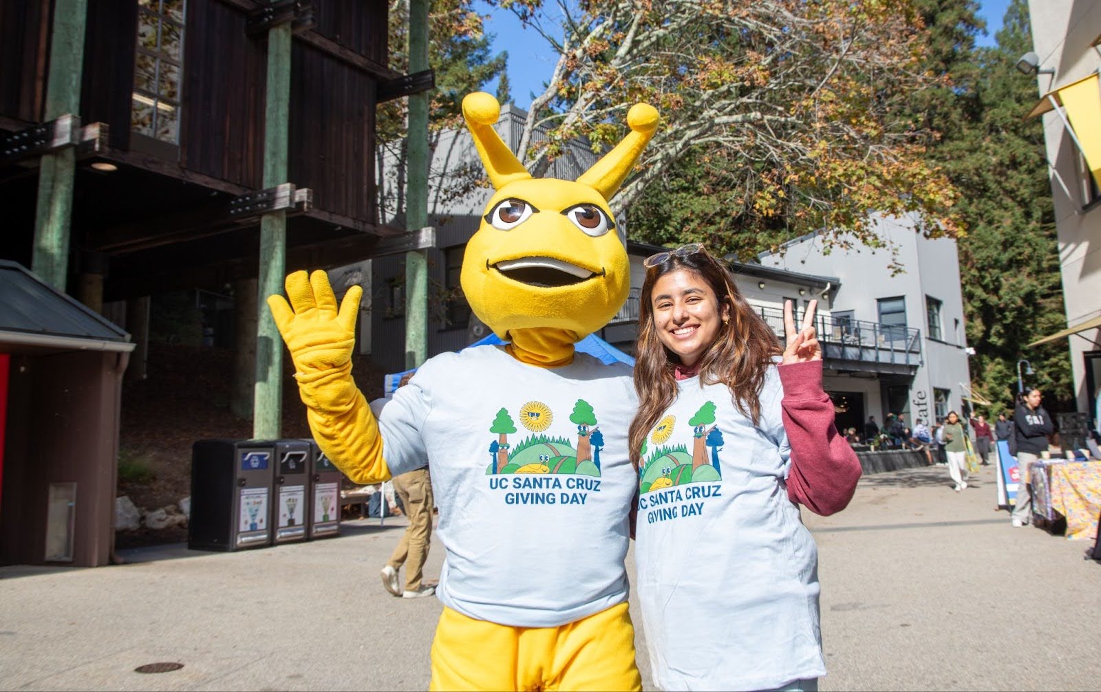 Student poses with Banana Slug Mascot.