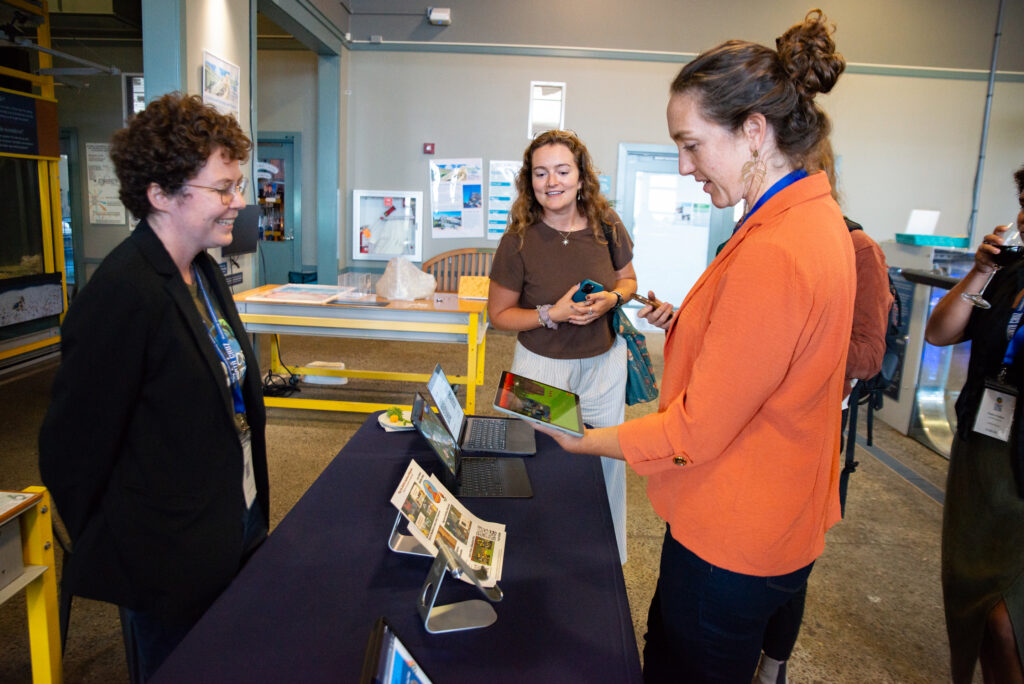 Symposium attendee holding a tablet with wildfire-preparedness video game open
