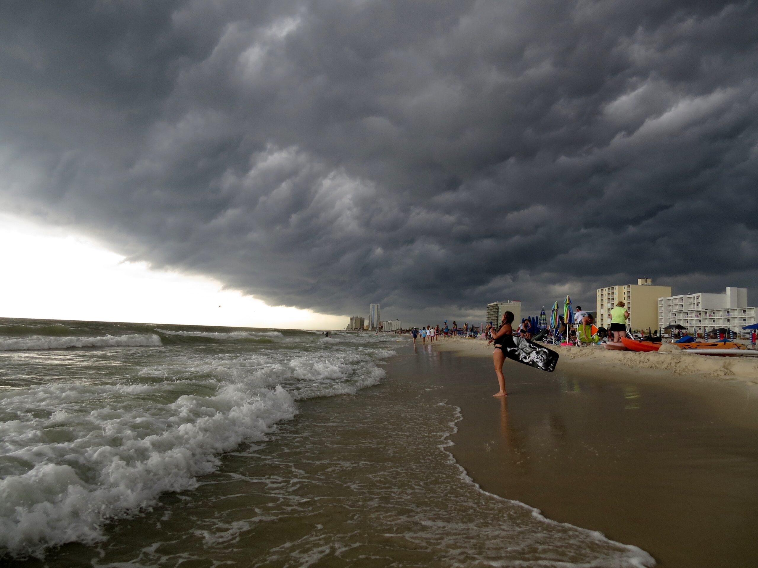 Image shows dark storm cloud above as a storm rolls into a beach on the Gulf of Mexico